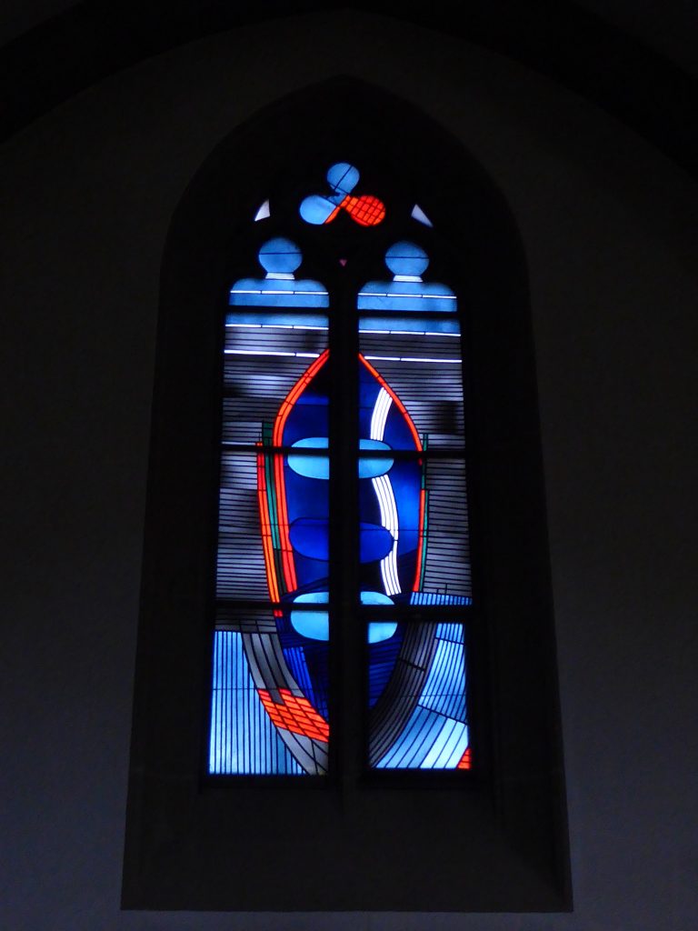 Seitenschiff – Dreifaltigkeitsfest: Die wesensgleichen drei göttlichen Personen (Vater, Sohn, Heiliger Geist) sind eingeschlossen in einer Mandorla (eine Art mandelförmiger Heiligenschein um eine ganze göttliche Figur herum) und umgeben vom Blau der Ewigkeit.