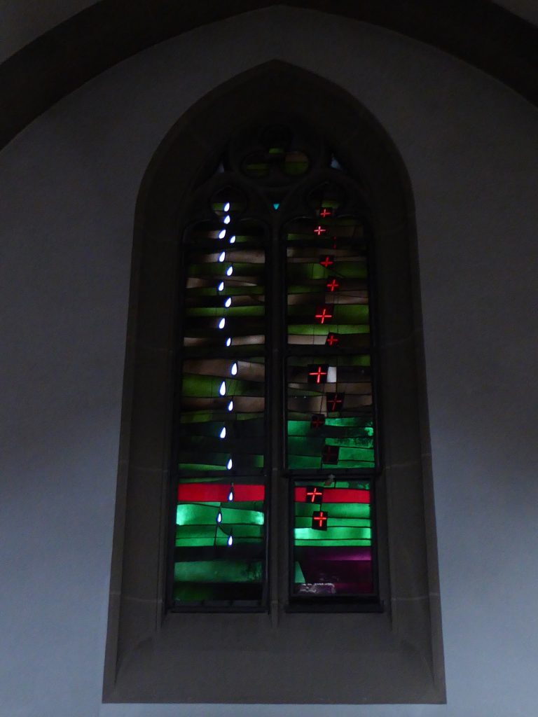 Seitenschiff – Allerheiligen und Allerseelen: Die weißen Flammen repräsentieren die zahllosen, oft unbekannten Heiligen. Die roten Kreuze erinnern an die Toten, derer an Allerseelen gedacht wird.