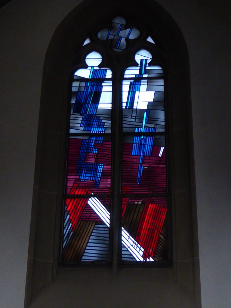 Seitenschiff – Ende und Vollendung der Welt: Inmitten von Not und Zerstörung erscheint der Menschensohn. Die Wiederkunft des Herrn ist durch die Farbe Weiß dargestellt, Ausdruck der Herrlichkeit Gottes.