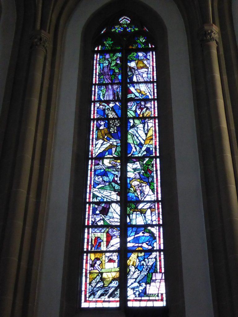 Rechtes Chorfenster: Das rechte Fenster zeigt Ereignisse aus dem Alten Testament. Von unten nach oben: Noah und die Arche (Gen 6), Abraham bei der Opferung seines Sohnes Isaak (Gen 22), das Mannawunder in der Wüste (Ex 16) und Gott als Schöpfer.